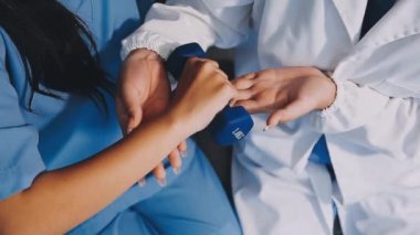 Üniformalı iki kadın doktor el sıkışıyor.