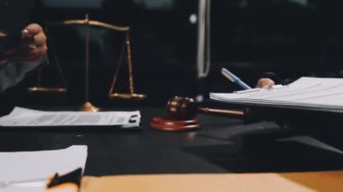 Takım elbiseli bir işadamı masada belgelerle çalışıyor.