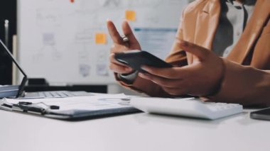 Ofiste cep telefonu ve tablet kullanan Asyalı genç iş adamını kapatın.