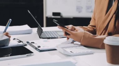 Modern ofiste finansal raporlarla çalışan genç iş adamları.