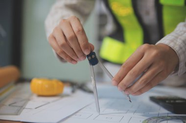 Mühendisler toplantı yapıyor ve ofiste bir planı tartışıyorlar. Mühendislik araçları ve inşaat konsepti