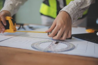 Mühendisler toplantı yapıyor ve ofiste bir planı tartışıyorlar. Mühendislik araçları ve inşaat konsepti