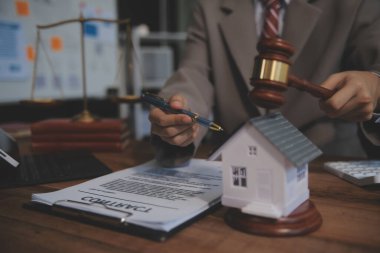 Emlak Hukuku, Ev Sigortası, Emlak Vergisi, Açık Artırma ve Açık Artırma Konsepti. Adliyedeki masasında tokmak adalet çekici olan küçük oyuncak ev modeli..