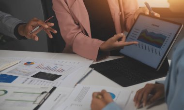 Modern dizüstü bilgisayarla gelir tabloları ve grafiklerini analiz eden iş ekibini kapatın. İş analizi ve strateji kavramı.