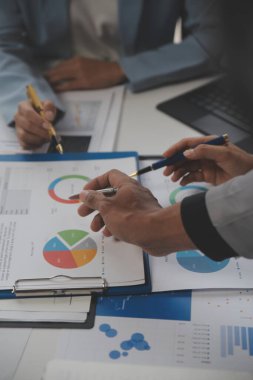 Modern dizüstü bilgisayarla gelir tabloları ve grafiklerini analiz eden iş ekibini kapatın. İş analizi ve strateji kavramı.