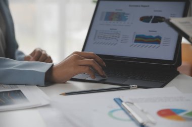 Modern dizüstü bilgisayarla gelir tabloları ve grafiklerini analiz eden iş ekibini kapatın. İş analizi ve strateji kavramı.