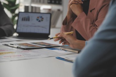 Modern dizüstü bilgisayarla gelir tabloları ve grafiklerini analiz eden iş ekibini kapatın. İş analizi ve strateji kavramı.