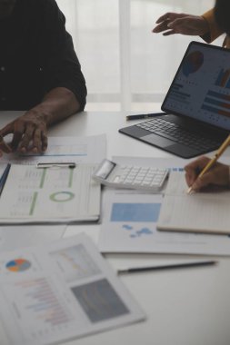 Modern dizüstü bilgisayarla gelir tabloları ve grafiklerini analiz eden iş ekibini kapatın. İş analizi ve strateji kavramı.