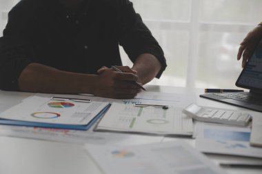 Modern dizüstü bilgisayarla gelir tabloları ve grafiklerini analiz eden iş ekibini kapatın. İş analizi ve strateji kavramı.