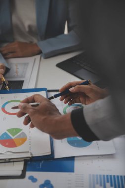 Modern dizüstü bilgisayarla gelir tabloları ve grafiklerini analiz eden iş ekibini kapatın. İş analizi ve strateji kavramı.
