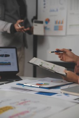 Modern dizüstü bilgisayarla gelir tabloları ve grafiklerini analiz eden iş ekibini kapatın. İş analizi ve strateji kavramı.