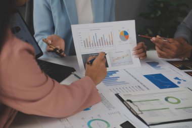 Modern dizüstü bilgisayarla gelir tabloları ve grafiklerini analiz eden iş ekibini kapatın. İş analizi ve strateji kavramı.