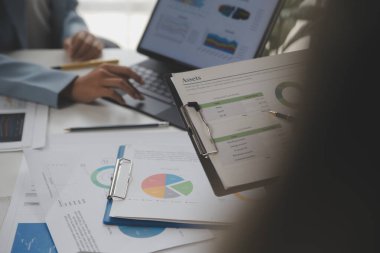 Modern dizüstü bilgisayarla gelir tabloları ve grafiklerini analiz eden iş ekibini kapatın. İş analizi ve strateji kavramı.