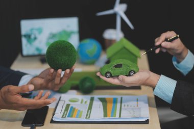 Yeşil Enerji Şirketi, güneş pili ve rüzgar türbini jeneratörü ile sürdürülebilir ve yenilenebilir temiz enerji ürünlerinin pazarlanmasını planlayan ve görüşen iş adamlarıyla görüşüyor. Önde.