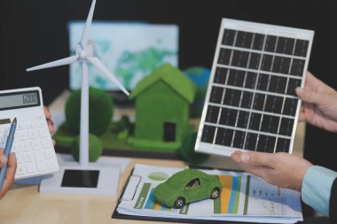 Yeşil Enerji Şirketi, güneş pili ve rüzgar türbini jeneratörü ile sürdürülebilir ve yenilenebilir temiz enerji ürünlerinin pazarlanmasını planlayan ve görüşen iş adamlarıyla görüşüyor. Önde.