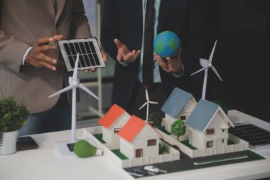 Yeşil Enerji Şirketi, güneş pili ve rüzgar türbini jeneratörü ile sürdürülebilir ve yenilenebilir temiz enerji ürünlerinin pazarlanmasını planlayan ve görüşen iş adamlarıyla görüşüyor. Önde.