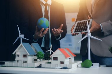 Yeşil Enerji Şirketi, güneş pili ve rüzgar türbini jeneratörü ile sürdürülebilir ve yenilenebilir temiz enerji ürünlerinin pazarlanmasını planlayan ve görüşen iş adamlarıyla görüşüyor. Önde.