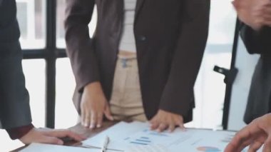 Modern ofiste finansal tablolar üzerinde çalışan iş adamları.