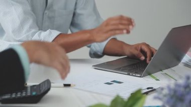 Ofis masasında dizüstü bilgisayarda çalışan bir iş adamı.