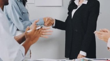 Genç iş kadını ofisteki meslektaşlarıyla tokalaşıyor