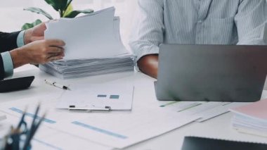 Modern ofiste çalışan iş adamları. Bilgisayarları ve belgeleri masanın üzerinde.