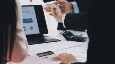 Ofiste bilgisayar üzerinde çalışan iş adamı ve kadın takımı.