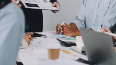 Bir grup iş adamı ofiste yeni fikirleri tartışıyor..