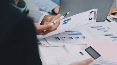 Ofiste iş ekibi toplantısı, laptopla çalışan iş adamları, masadaki mali raporlar, üst görünüm.