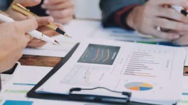 İş adamı, ofis masasında hesap makinesiyle iş haritalarını analiz ediyor.