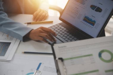 Close up of Business team analyzing income charts and graphs with modern laptop computer. Business analysis and strategy concept.