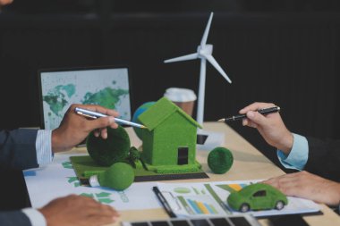 Yeşil Enerji Şirketi, güneş pili ve rüzgar türbini jeneratörü ile sürdürülebilir ve yenilenebilir temiz enerji ürünlerinin pazarlanmasını planlayan ve görüşen iş adamlarıyla görüşüyor. Önde.