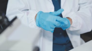 Elinde tıbbi eldiven tutan bir doktora yaklaş.