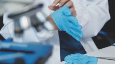 Doktor elinde tıbbi eldiven ve enjeksiyon için şırınga tutuyor.