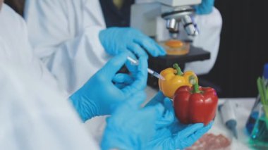 Eldivenli laboratuvar asistanı taze sebzeli bir bardak tutuyor.