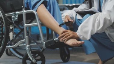 Doktor tekerlekli sandalyede el ele tutuşan kadın.
