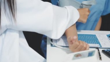 Genç Asyalı kadın doktor bir hastayı elinde tutuyor.