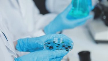 Yakın plan. Laboratuvarda aşıyla tüp tutan bir bilim adamı.