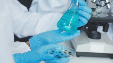 Laboratuvar asistanı test tüpünü tutuyor