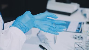 Doktor elini mavi eldivenli, elinde test tüpleriyle kapat.