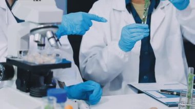 Laboratuvar asistanı elinde kan örneğiyle test tüpü tutuyor..