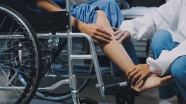 Doktor ve hemşire hastayla birlikte tekerlekli sandalyede.