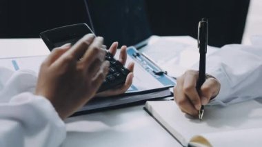 İş kadını ofisteki hesap makinesinde el yazısı