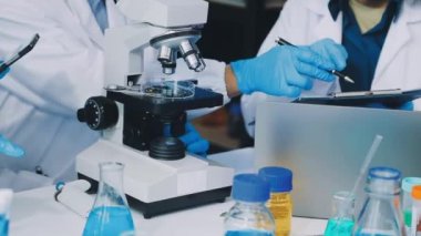 Laboratuvarda elinde tüp tutan bilim adamının yakın çekimi.