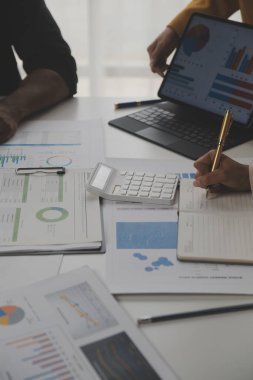 Modern dizüstü bilgisayarla gelir tabloları ve grafiklerini analiz eden iş ekibini kapatın. İş analizi ve strateji kavramı.