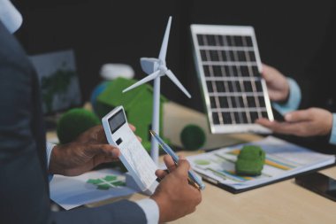 Yeşil Enerji Şirketi, güneş pili ve rüzgar türbini jeneratörü ile sürdürülebilir ve yenilenebilir temiz enerji ürünlerinin pazarlanmasını planlayan ve görüşen iş adamlarıyla görüşüyor. Önde.