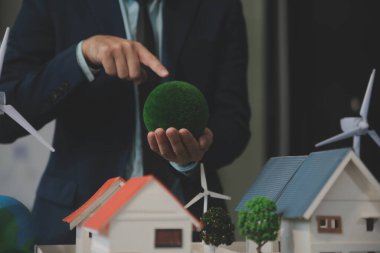 Yeşil Enerji Şirketi, güneş pili ve rüzgar türbini jeneratörü ile sürdürülebilir ve yenilenebilir temiz enerji ürünlerinin pazarlanmasını planlayan ve görüşen iş adamlarıyla görüşüyor. Önde.