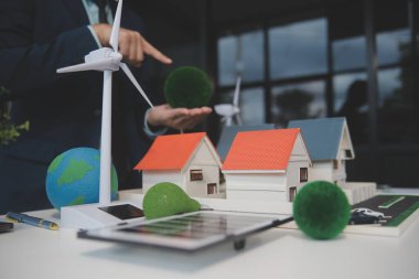 Yeşil Enerji Şirketi, güneş pili ve rüzgar türbini jeneratörü ile sürdürülebilir ve yenilenebilir temiz enerji ürünlerinin pazarlanmasını planlayan ve görüşen iş adamlarıyla görüşüyor. Önde.