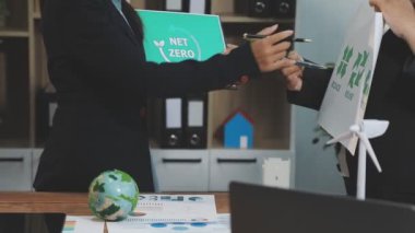 Elinde yeşil bitki olan bir iş kadını.