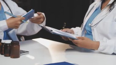 Doktorlar ellerinde haplarla pano tutuyorlar.