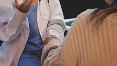 Kadın doktor hastasına el sıkışıyor.